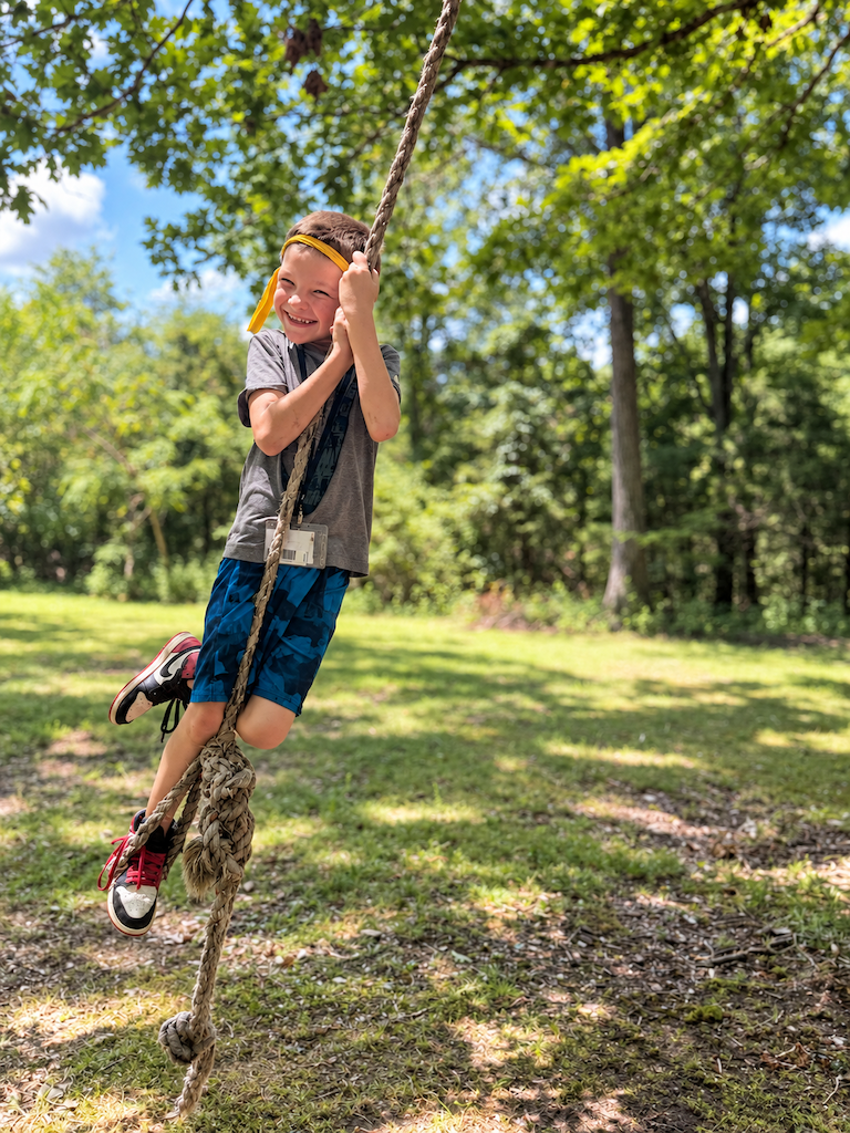 Smiling camper on a forest rope course-1